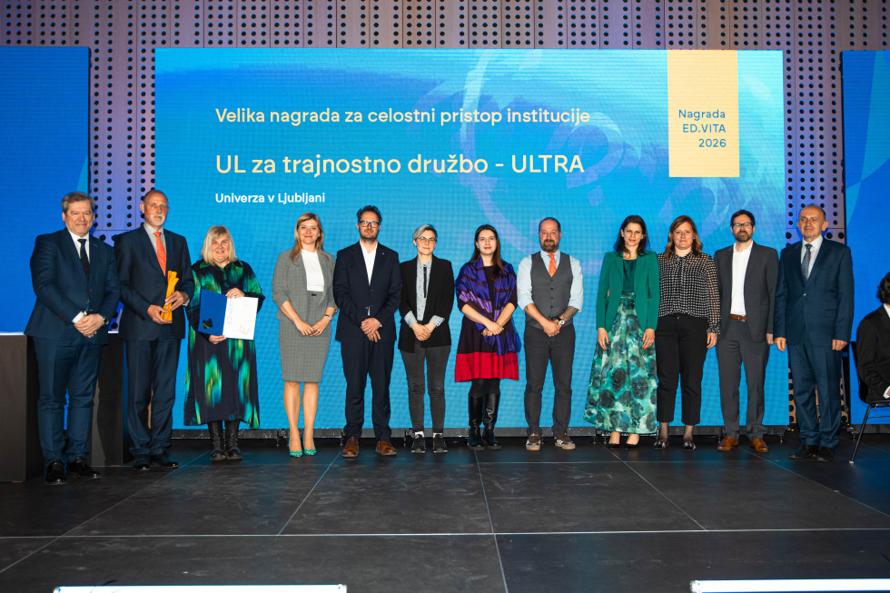 Skupina prejemnikov in predstavnikov institucij stoji na odru pred velikim zaslonom z napisom »Velika nagrada za celostni pristop institucije – UL za trajnostno družbo – ULTRA«.