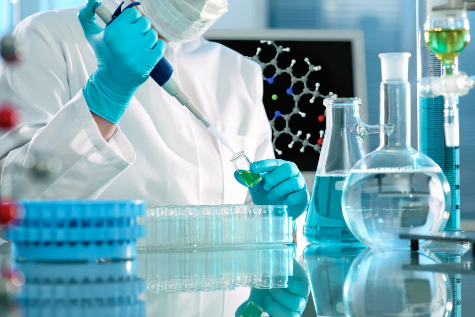 Raziskovalec v laboratoriju s pipeto.