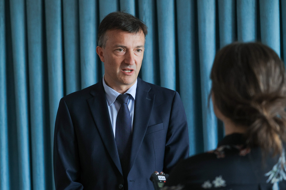 Državni sekretar za znanost in inovacije na Ministrstvu za visoko šolstvo, znanost in inovacije dr. Jure Gašparič med izjavo za medije, v ospredju novinarka z diktafonom.