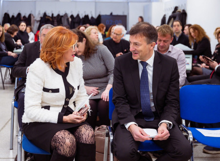 Moški in ženska sedita na stolih in se pogovarjata. 