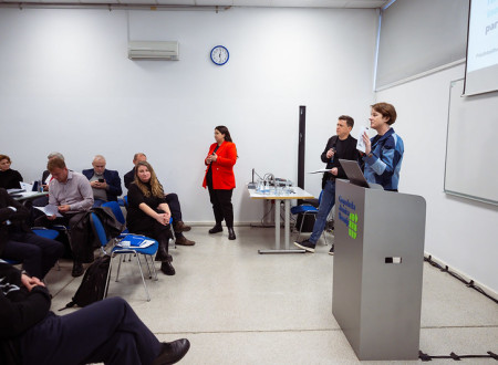 Ženska stoji na odru in govori.