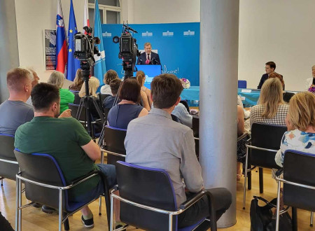 Novinarji in novinarke ter kamere na izjavi za javnost ob podpisu pogodbe. V ozadju minister dr. Papič.