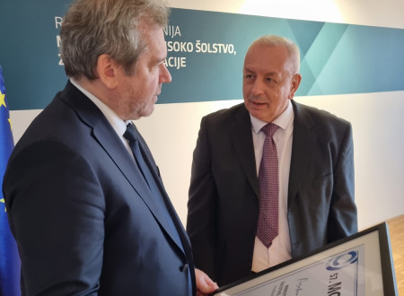 Minister Papič in gospod Škrlec v pogovoru ob predaji priznanja.