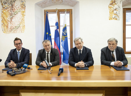 Govorci za mizo po podpisu pisma o nameri. V ozadju evropska, slovenska in novogoriška zastava.