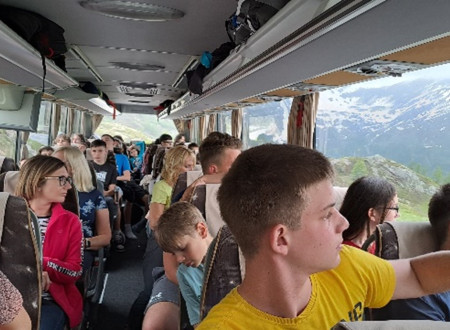 Zmagovalci sivih celic na avtobusu, opazujejo pokrajino. 