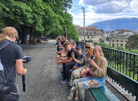 Lesena klop v Ženevi – 120 metrov dolga klop, priljubljeno zbirališče domačinov in turistov. Sedijo zmagovalci kviza in mentorice. 