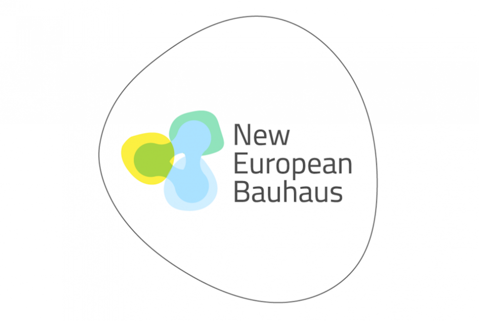 Logotip misije Novi evropski Bauhaus, ki ima obliko nekoliko popačenega kroga, na desni polovici je v treh vrsticah izpisano New European Bauhaus, na levi polovici pa je v pastelnih odtenkih modre, zelene in rumene trikotna abstraktna forma.