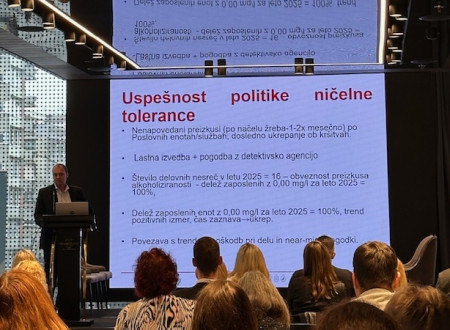 Udeleženci poslušajo predavatelja. Na steni veliko platno s podatki inšpekcijskih služb.