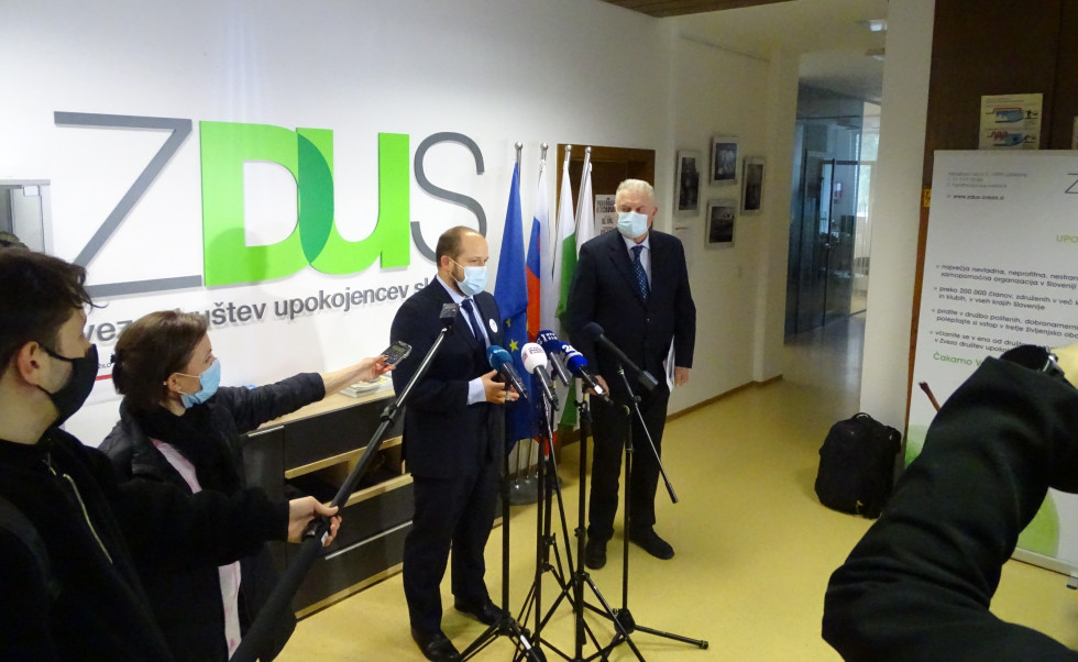 Minister daje izjavo pred množico mikrofonov, desno stoji predsednik ZDUS Janez Sušnik, v ozadju logotip ZDUS.
