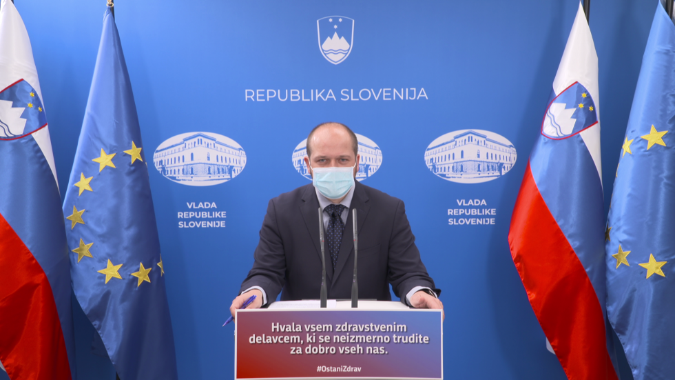 Janez Poklukar za govorniškim pultom v vladnem tiskovnem središču.