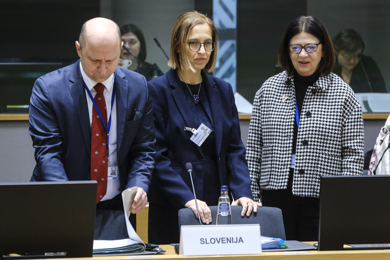 Skupina odraslega moškega in dveh žensk, med njimi ministrica za zdravje, stoji pred mizo, na kateri je napis Slovenija