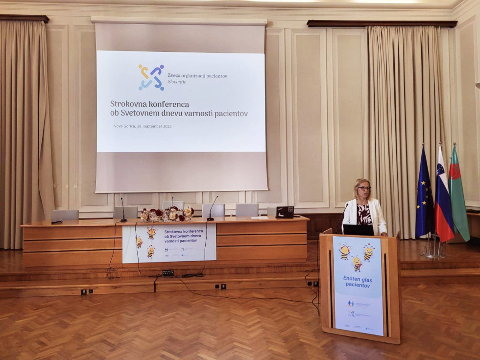 Ministrica stoji za govorniškim pultom, v ozadju napis strokovne konference