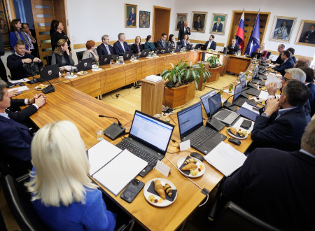 Mize v U obliki, za katerimi sedijo predstavniki Vlade