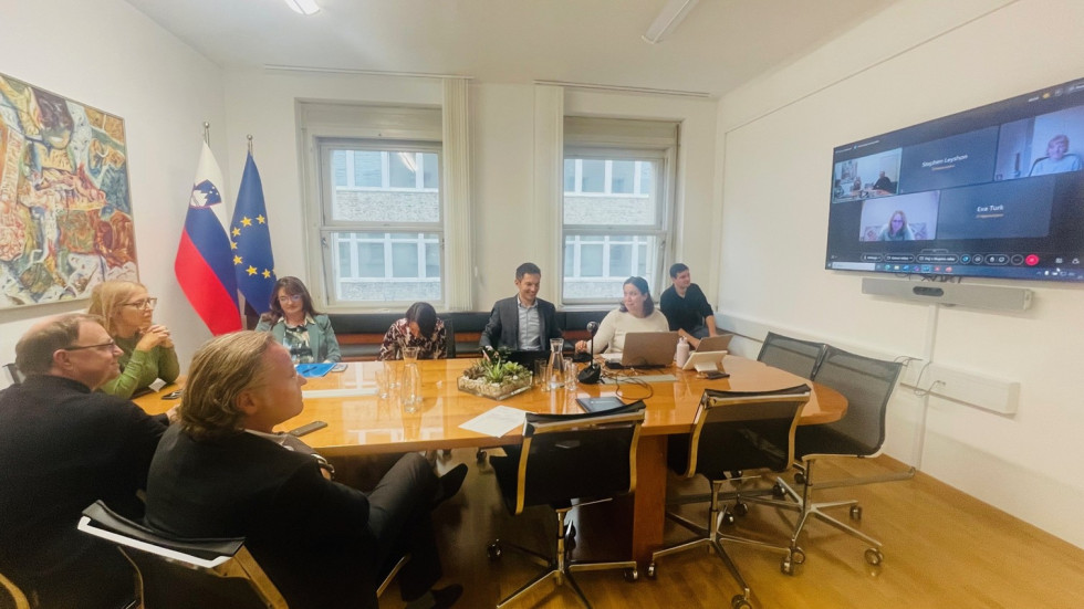 Člani in članice sveta sedijo za ovalno mizo