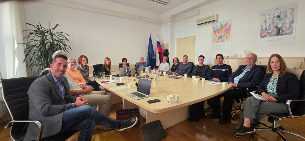 Predstavniki podjetij in ministrstva sedijo za kvadratno mizo