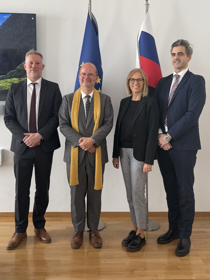 3 Moški in ministrica stojijo v ozadju slovenska zastava in zastava EU