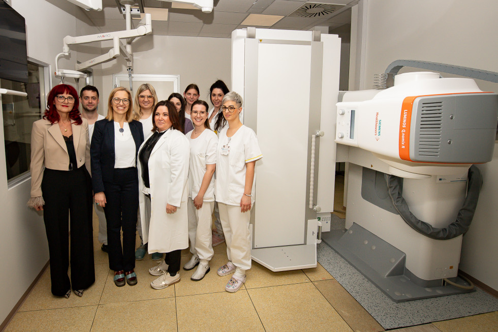 Ženske in moški stojijo zraven naprave.