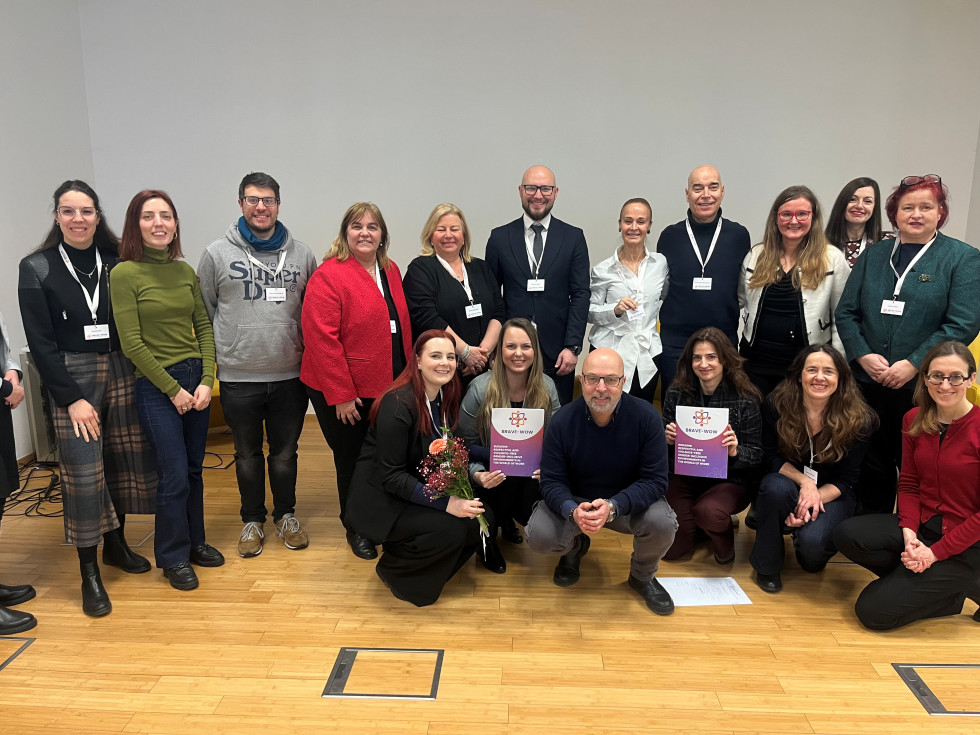  Na fotografiji pozira večje število moških in žensk, na sredini je državni sekretar.