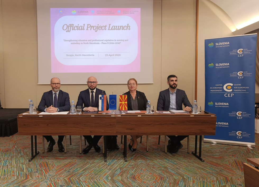 Skupina sedi za mizo in govori - Denis Kordež med govorniki