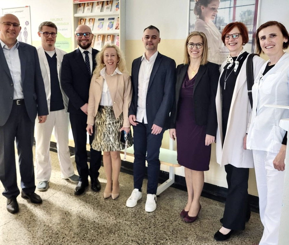 Skupinska fotografija več moških in žensk, nekateri od njih so v belih zdravniških uniformah.