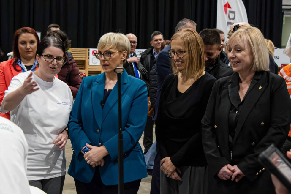 Predsednica države in ministrica stojita ena zraven druge. Poleg njiju stojijo druge ženske.