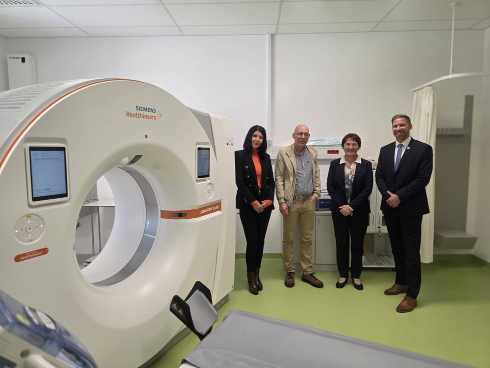 Dve ženski in dva moška stojijo pred velikim okroglim diagnostičnim aparatom.