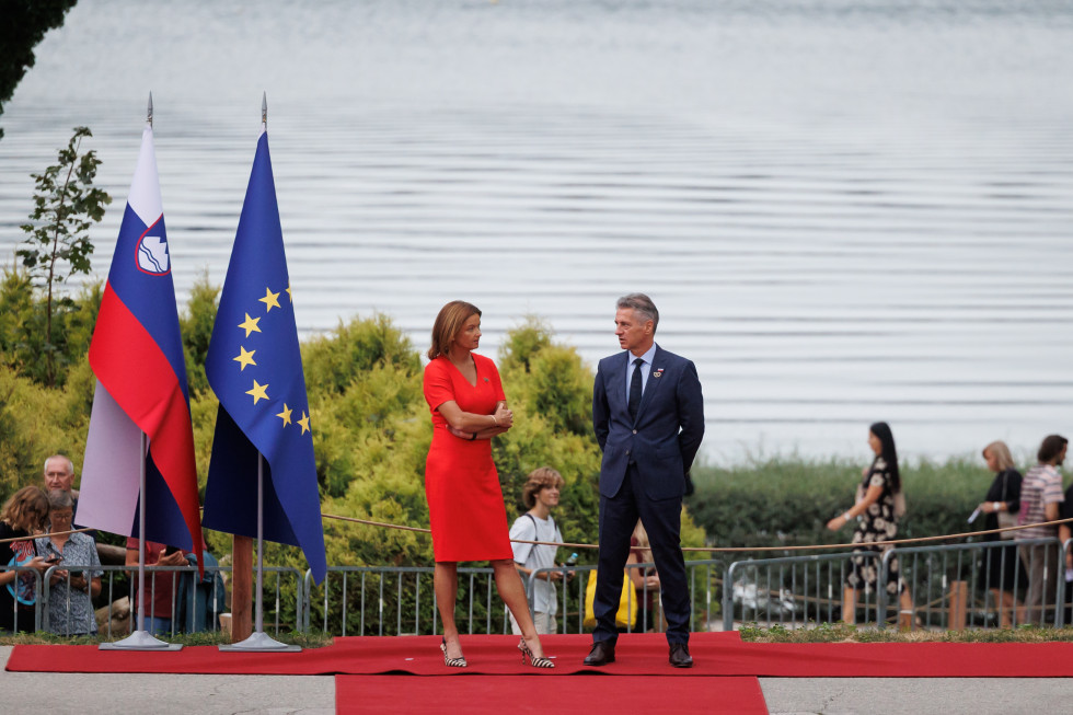 Ministrica Tanja Fajon in predsednik vlade dr. Robert Golob pred Festivalno dvorano na rdeči preprogi, v ozadju Blejsko jezero