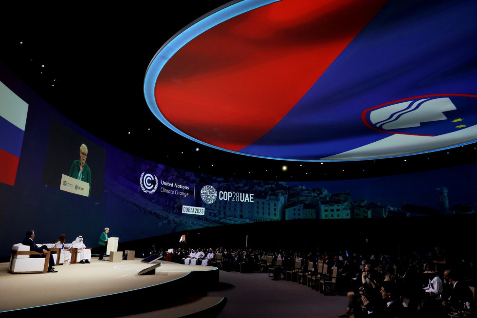 Nagovor predsednice Pirc Musar na otvoritvi dogodka. Nad dvorano je lasersko prikazana velika slovenska zastava..