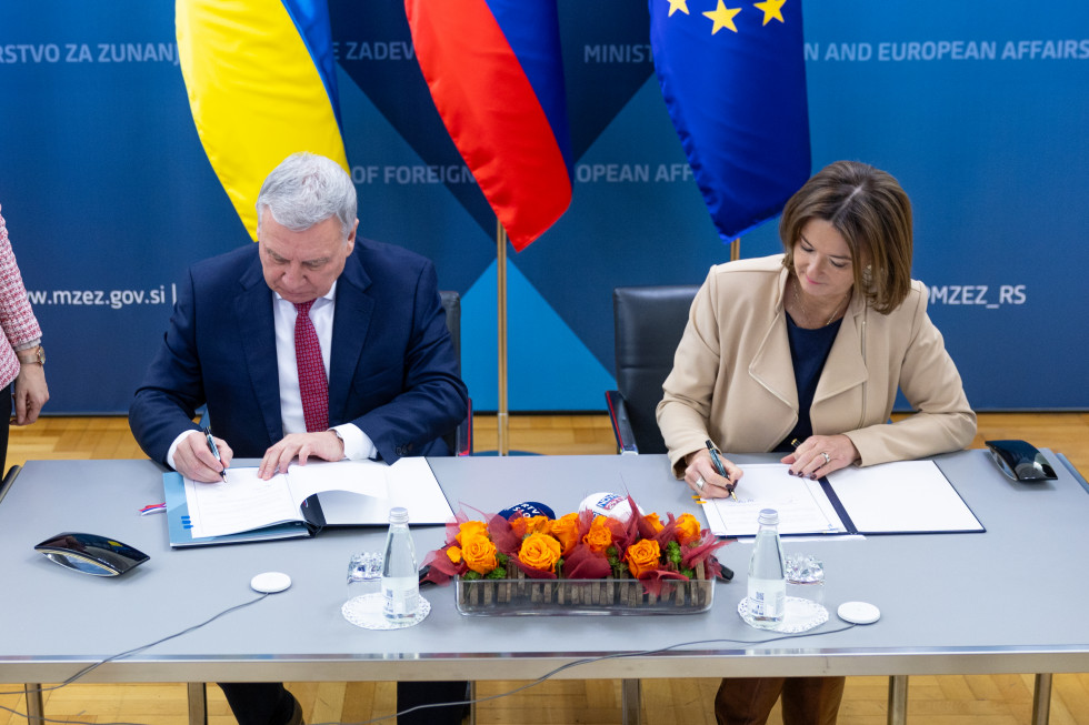 signing agreement, sitting at the table, minister Fajon and 