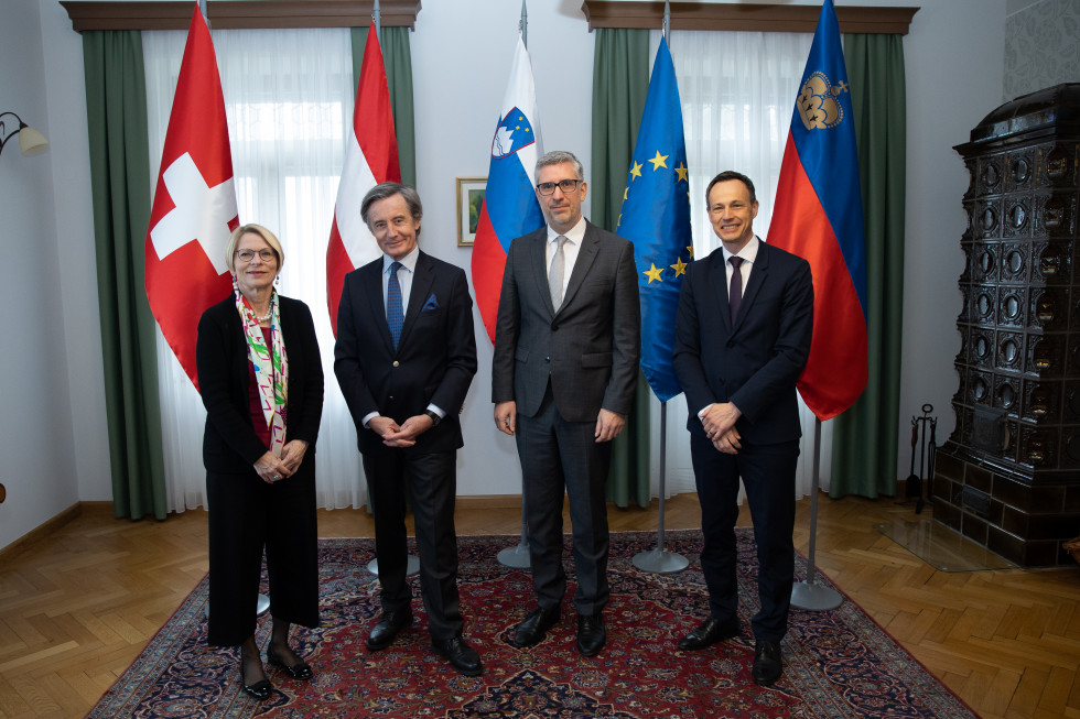 Namestniki zunanjih ministrov Švice, Avstrije, Slovenij in Lihenštajna stojijo pred zastavami vseh držav in EU
