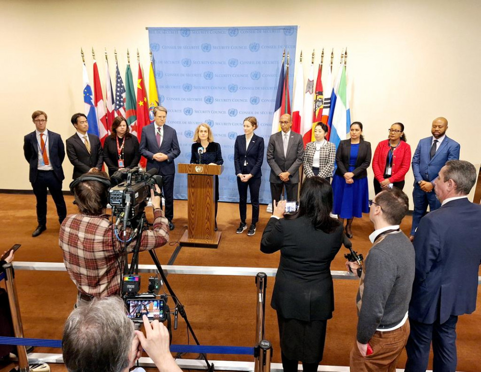 Skupna izjava predstavnikov Slovenije v Varnostnem svetu Združenih narodov, stojijo eden poleg drugega pred zastavami članic Varnostnega sveta, spredaj novinarji s kamerami