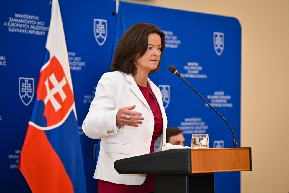 ministrica za govorniškim pultom nagovarja slovaške veleposlanike