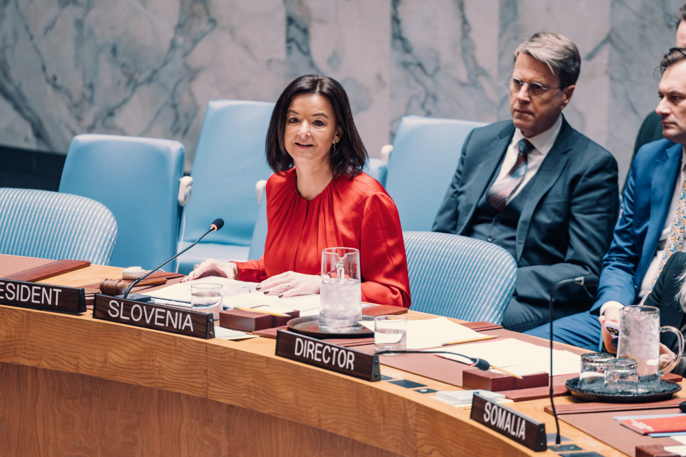 ministrica Fajon sedi na moder stolu, govori