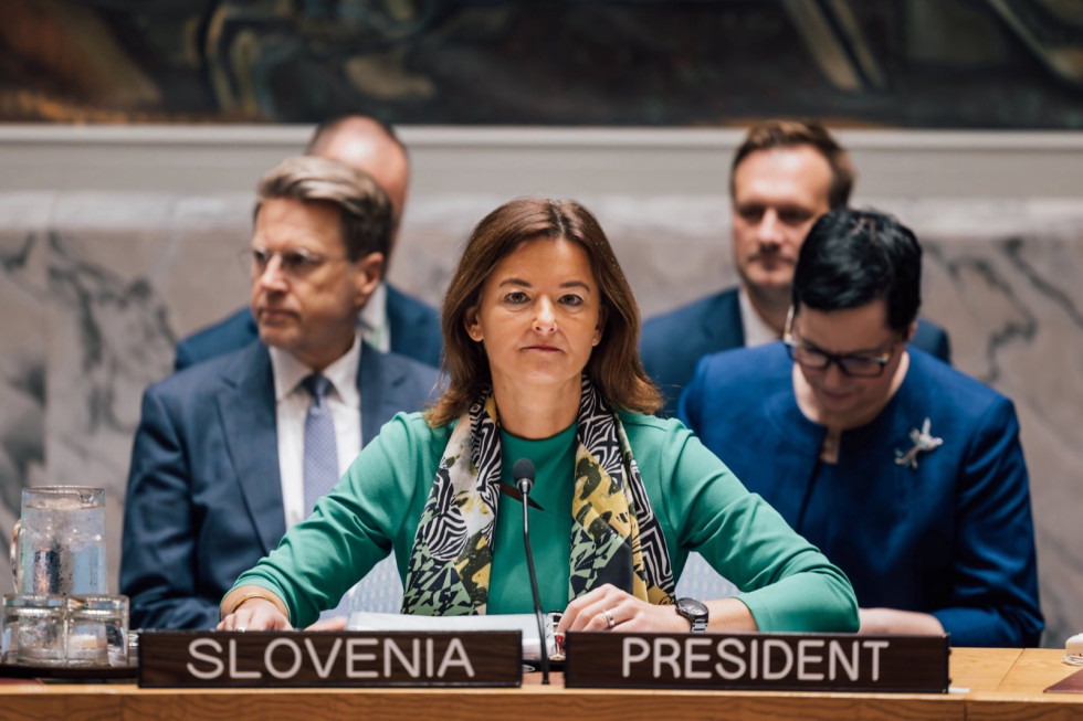 ministrica Fajon sedi za mizo, pred njo napis Slovenija in predsednik