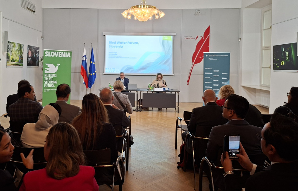 Pogled po dvorani, na odru za mizo državna ženska in moški