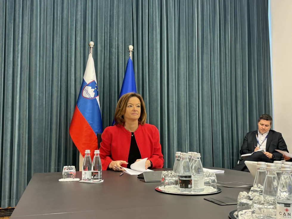 ministrica sedi, v ozadju slovenska in evropska zastava