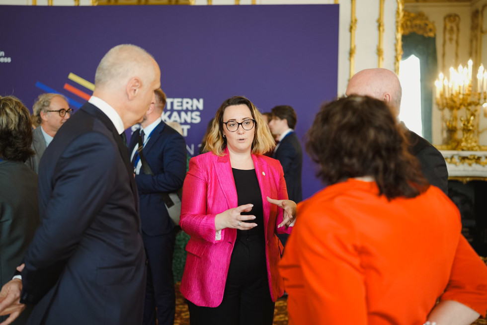 Ženska govori z drugimi udeleženci