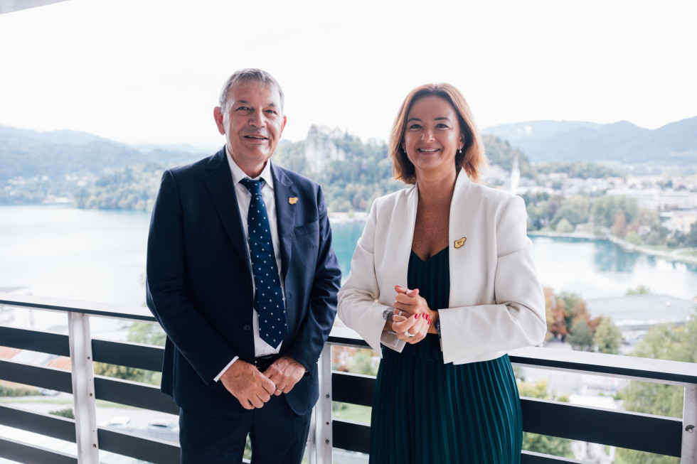 standing on balcony, both smiling, behind is Bled Lake