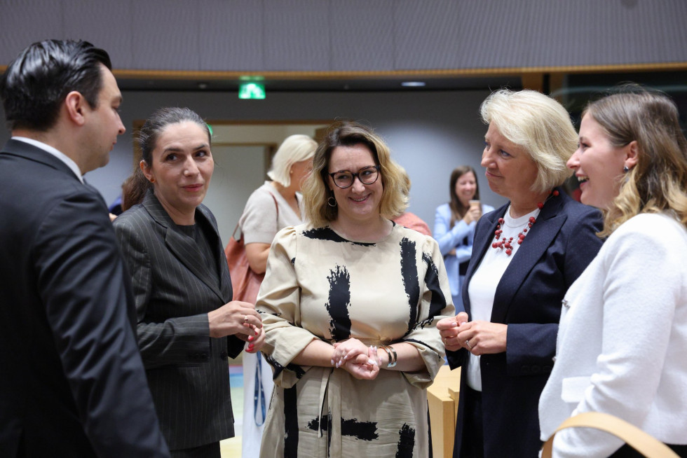 državna sekretarka stoji in govori s svojimi pandani