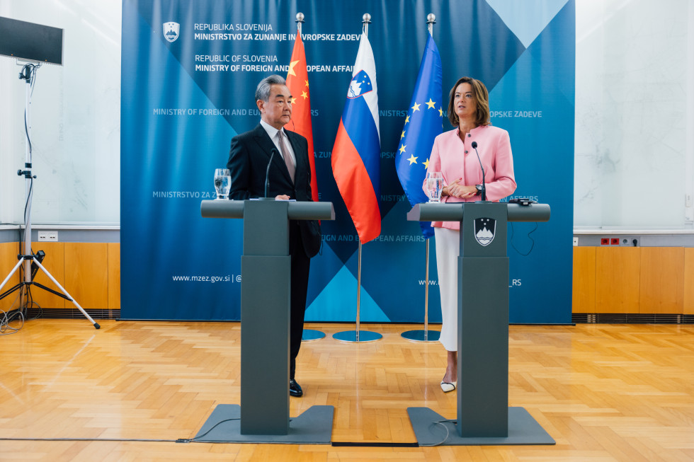 novinarska konferenca, govorniki, oba stojita za mikrofoni, v ozadju zastave