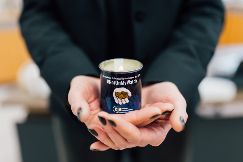 Women's hands hold a candle.