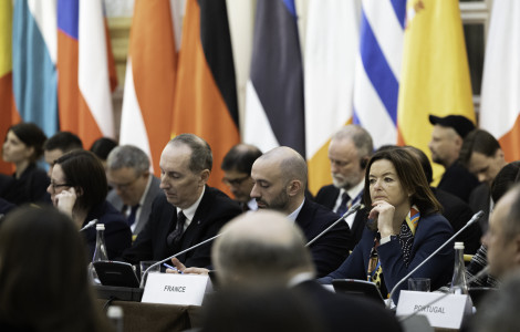 IM 6299 (Ministri sedijo in govorijo, zadaj zastave.)