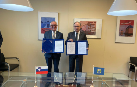 44729e40 23a2 4ab3 acbe 82b93938e477 (two men standing and showing documents in their hands)