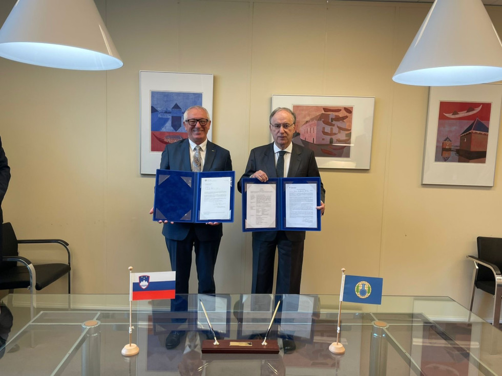two men standing and showing documents in their hands