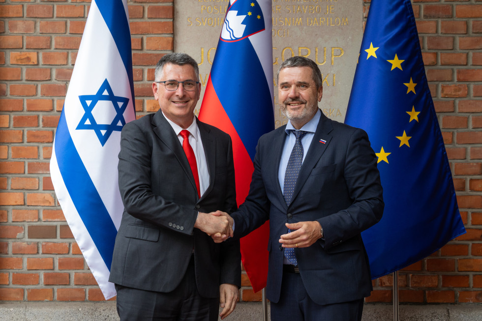 ministra se rokujeta pred zastavami
