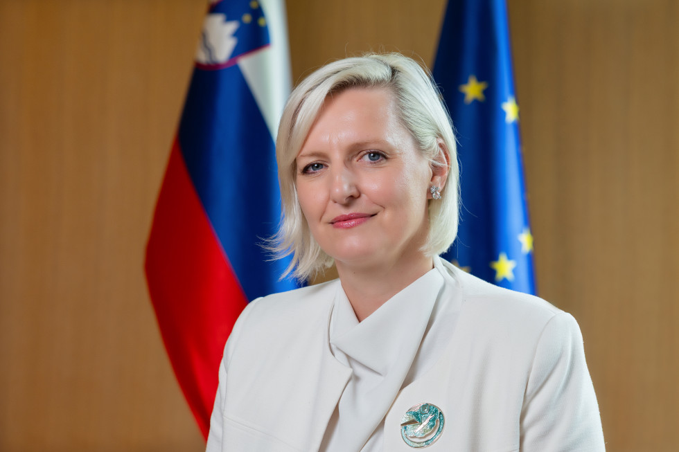 portrait photograph in front of the Slovenian and EU flags