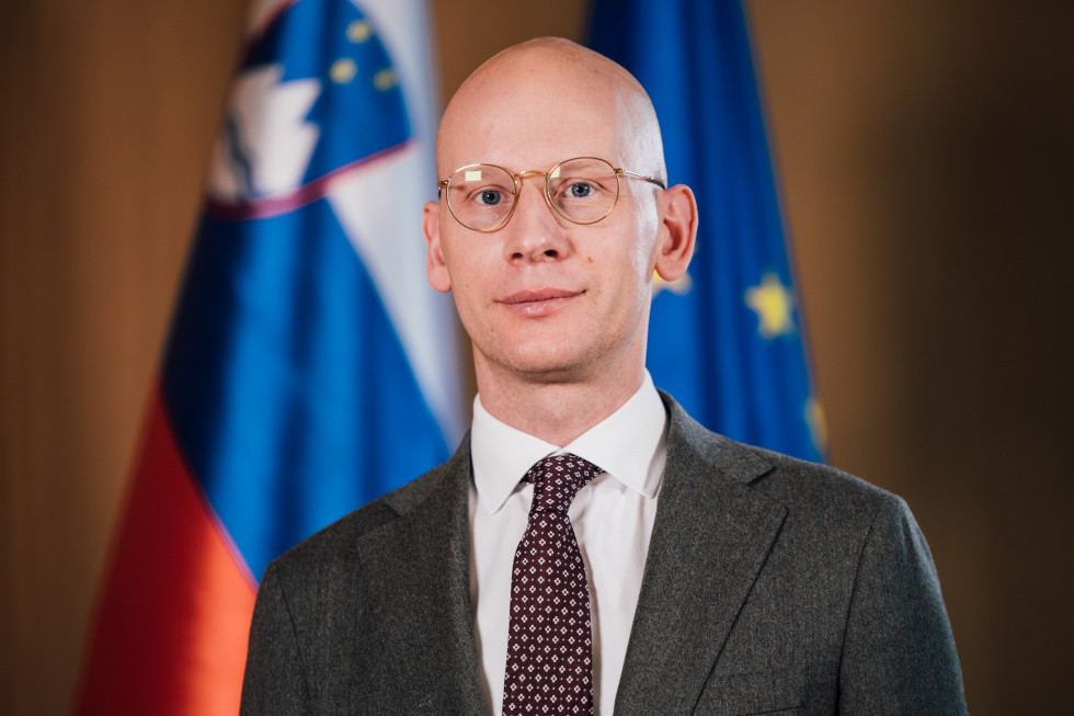 portrait photograph in front of the Slovenian and EU flags
