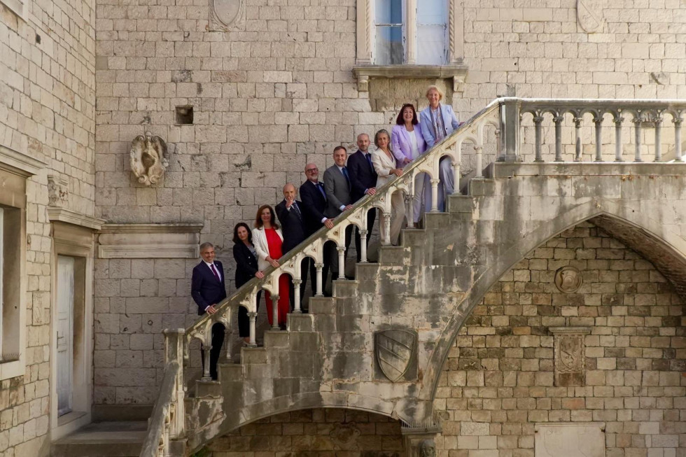 udeleženci srečanja stojijo na stopnicah in se fotografirajo