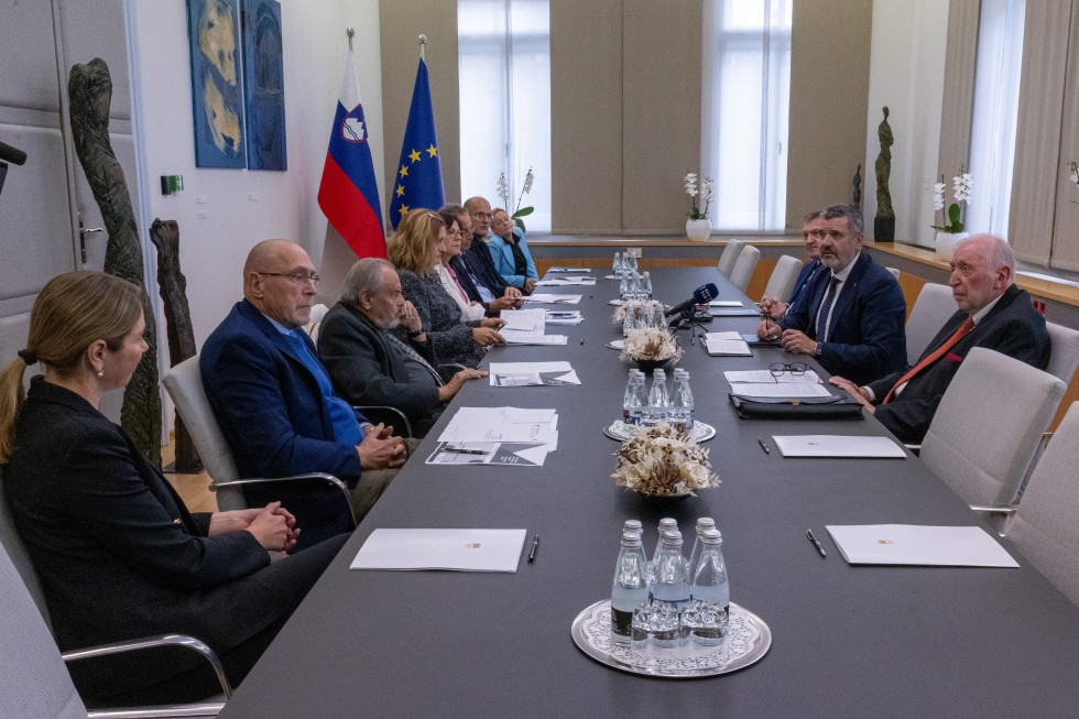 ljudje se pogovarjajo za dolgo mizo