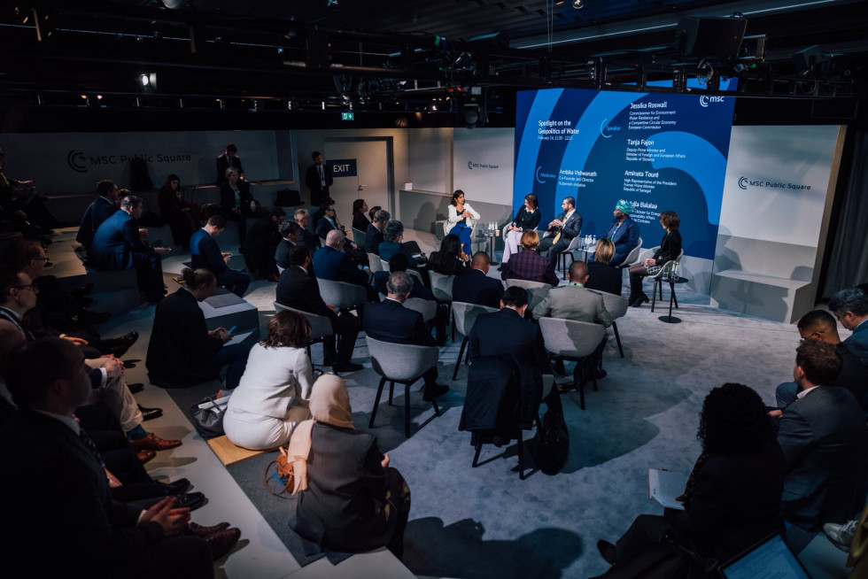 Govorci sedijo in govorijo. V dvorani sedijo poslušalci in jih opazujejo.